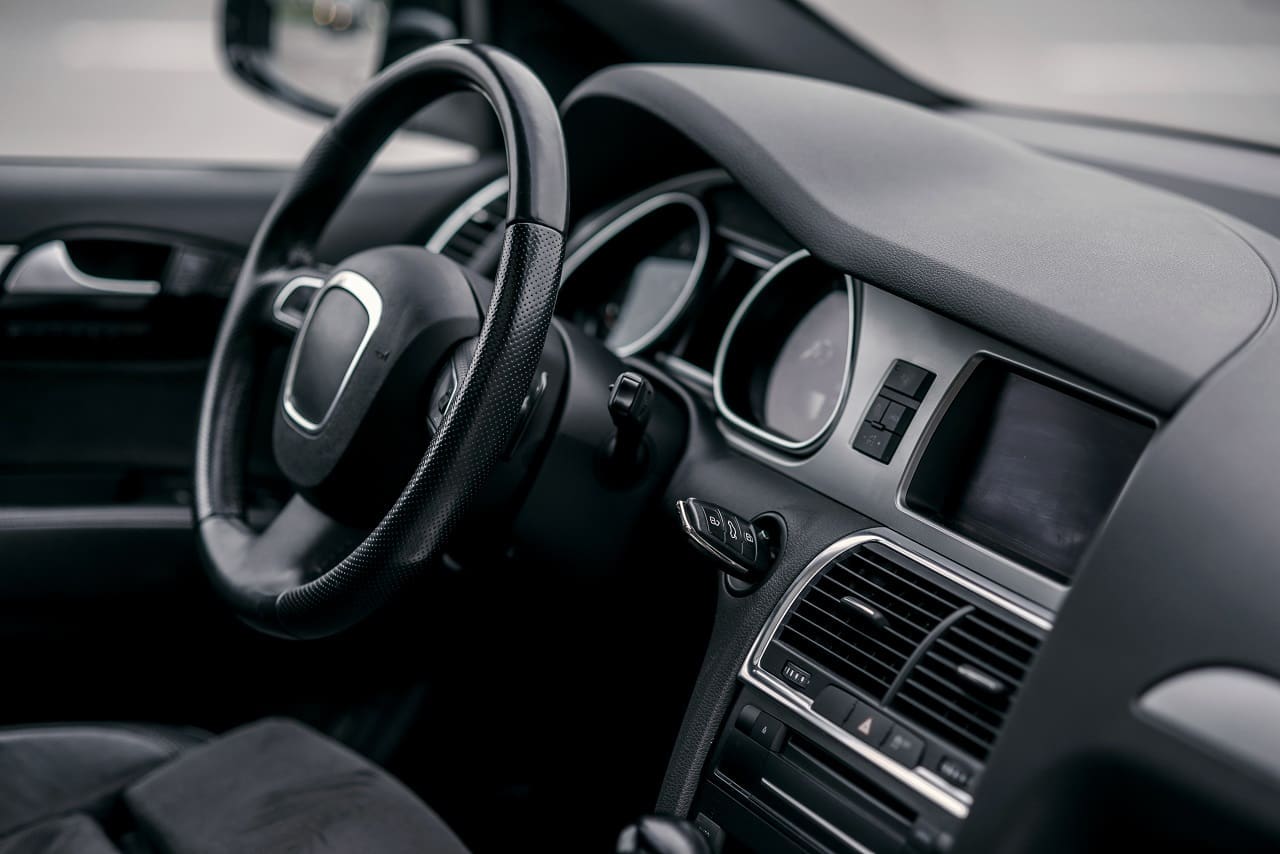 Close-up view of a modern car interior showing the steering wheel, dashboard, air vents, and part of the center console.